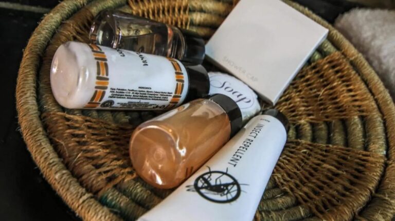Une corbeille tressée garnie de produits d'accueil, dont un répulsif anti-insectes