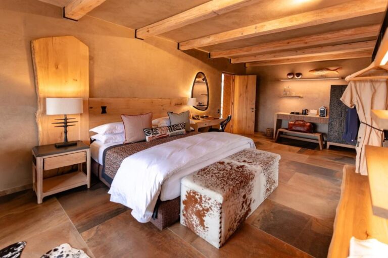 Une suite au grand lit, avec un banc en peau de vache, un coin café et un peignoir suspendu