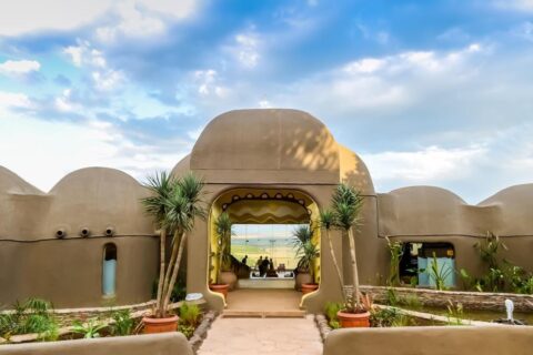 L'entrée du Mara Serena Safari Lodge, ses dômes couleur de terre et la savane dans l'encadrement de la porte
