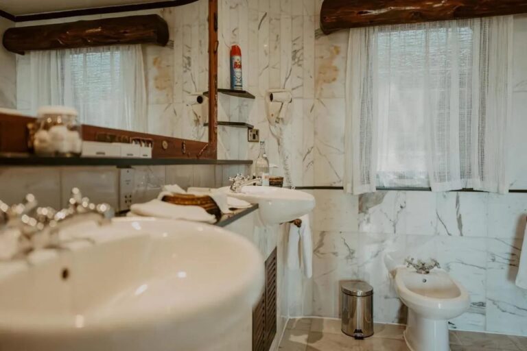 Un lavabo en gros plan dans une salle de bains en marbre, avec un bidet au fond
