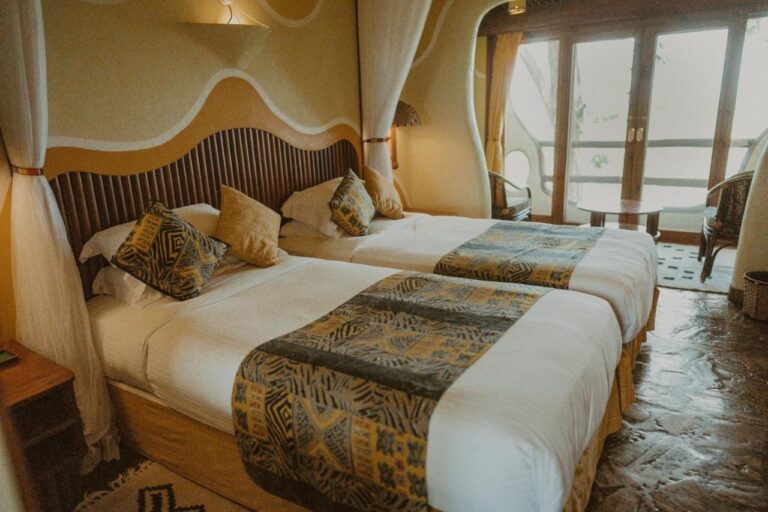 Une chambre à deux lits, ouverte sur le balcon par une porte-fenêtre