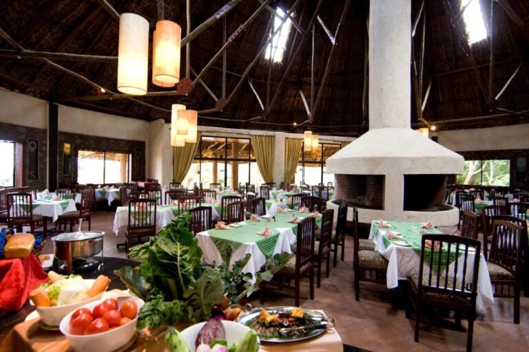 Le restaurant, ses tables aux nappes vertes et un buffet de légumes au premier plan