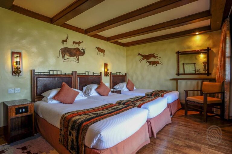 Une chambre triple sous des poutres en bois, avec des animaux peints sur les murs