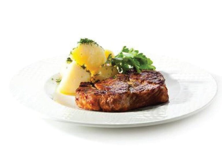 Une pièce de viande grillée avec des pommes de terre et des herbes