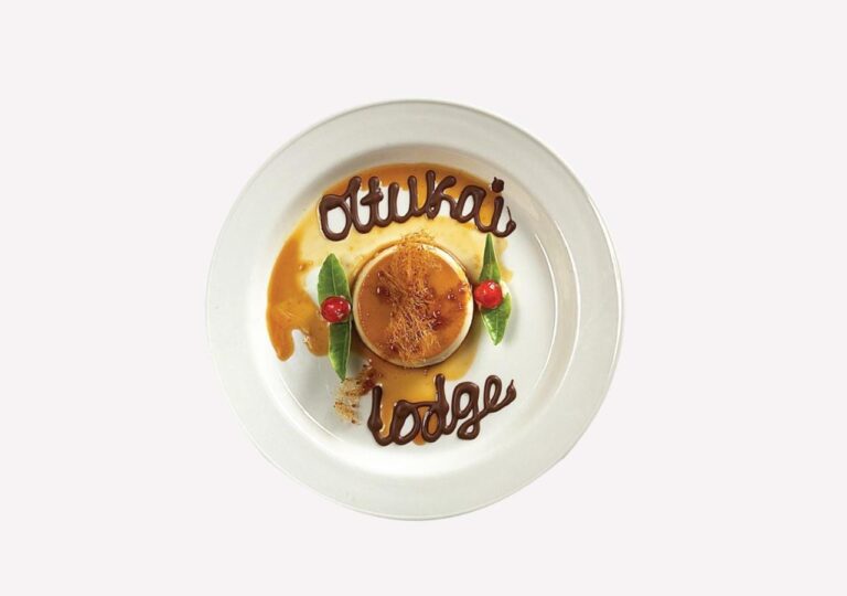Un flan au caramel, avec Ol Tukai Lodge écrit au chocolat sur l'assiette