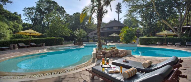La piscine en forme de lagon du Sarova Mara Game Camp, autour d'un îlot de rochers planté d'un palmier
