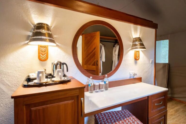 Une coiffeuse avec un miroir rond, un plateau à thé et une bouilloire