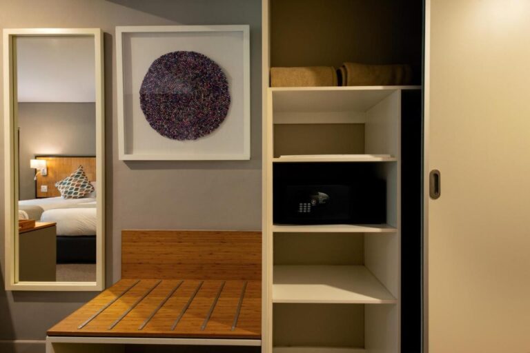 Le rangement d'une chambre, avec étagères, coffre-fort, porte-bagages et miroir