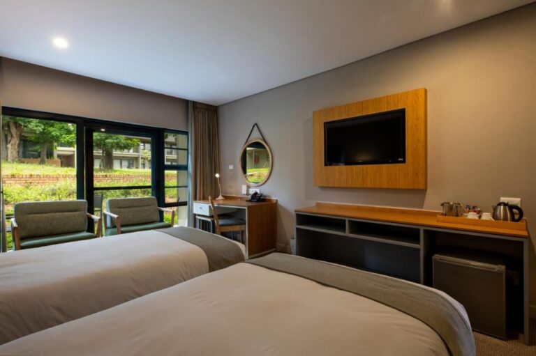 Une chambre à deux lits, avec télévision, bouilloire et vue sur le jardin