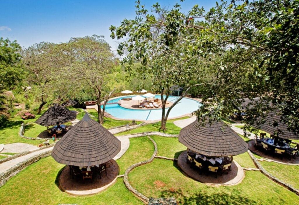 La piscine du Tarangire Sopa Lodge et ses paillotes au toit de chaume, au milieu des arbres